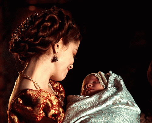 Charlotte Hope as Catherine of Aragon with her first-born son Henry, the New Year's prince, in The Spanish Princess Season 2.